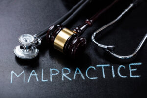 "malpractice" written on the page with a gavel and stethoscope above